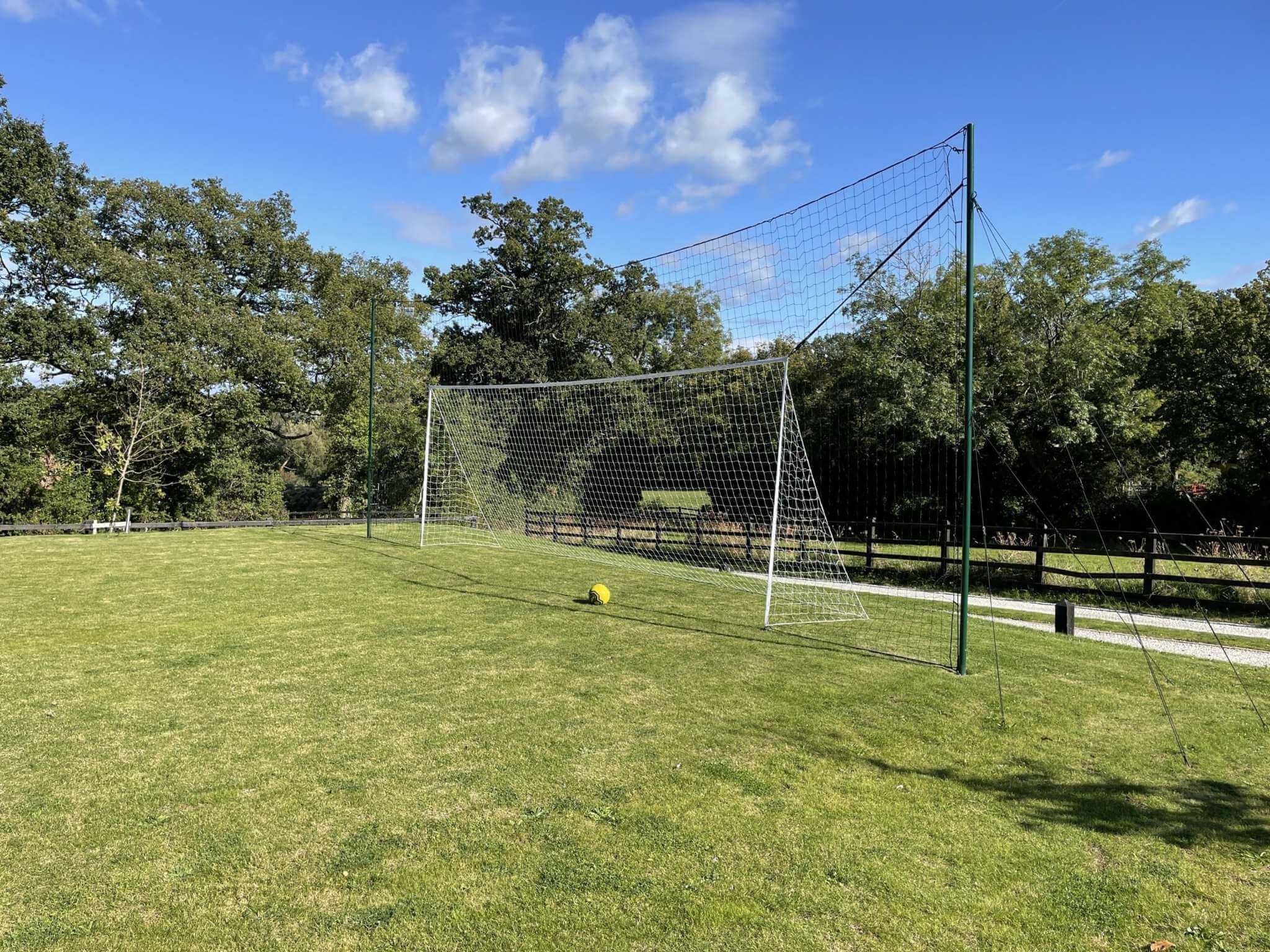 Football goal 24x8ft with rebound system installed on grass pitch